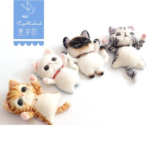 May include: Four felted cat figurines in various poses. The cats are white with different colored markings, including orange, gray, and brown. Each cat has a small bell around its neck.