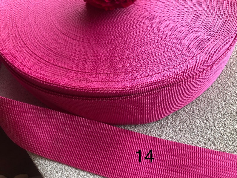 May include: A roll of pink nylon webbing, 1 inch wide. The webbing is rolled up and the end of the roll is labeled with the number "14".