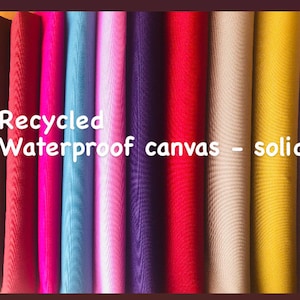 Puede incluir: Una colección de 10 rollos de tela de lona impermeable reciclada en colores sólidos, que incluyen marrón, rojo, rosa, azul, rosa claro, morado, rojo, beige, amarillo y lavanda. Lona impermeable reciclada - Sólidos