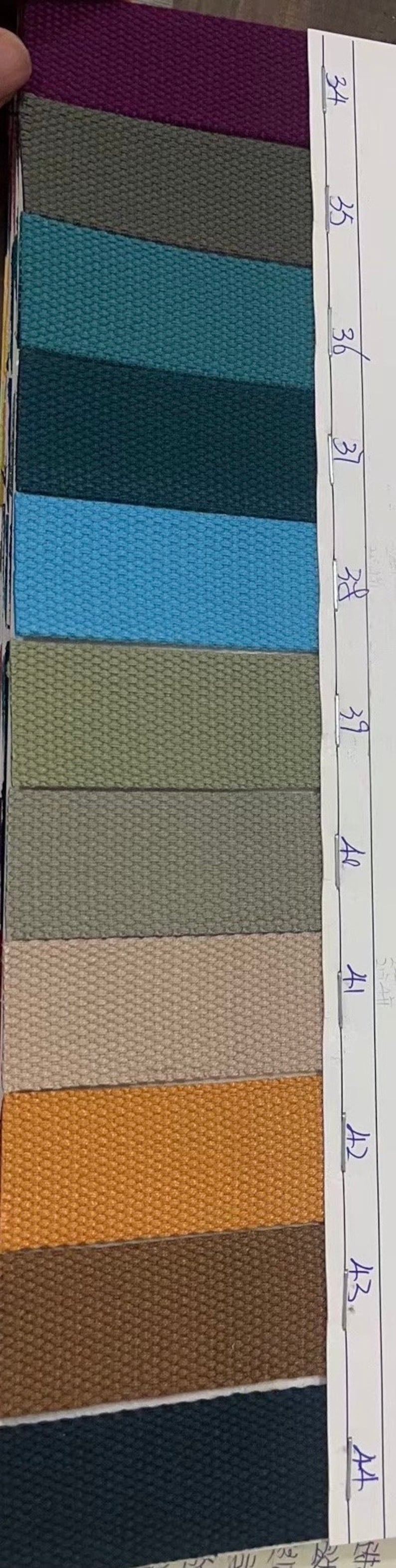 May include: A swatch card with 10 fabric samples in various colors and textures. The samples are labeled with numbers 38, 39, 40, 41, 42, 43, and 44.