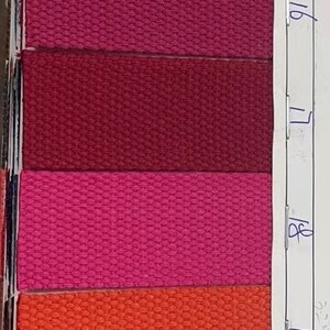May include: A sample card with numbered swatches of different colored woven webbing. The colors include red, black, white, green, pink, burgundy, orange, purple, and gold.