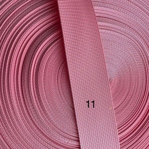 May include: A roll of pink webbing with a close-up of the webbing showing the texture. The number "11" is printed on the webbing.