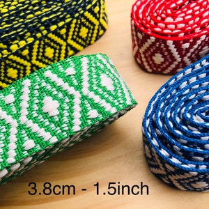 May include: Four different patterned woven trims in blue, red, green, and yellow. The trims are 1.5 inches wide and have a geometric design. 3.8cm - 1.5inch