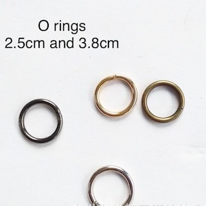 Puede incluir: Cuatro anillos en O de diferentes tamaños y colores: negro, dorado, plateado y bronce. Los anillos tienen un diámetro de 2,5 cm y 3,8 cm.