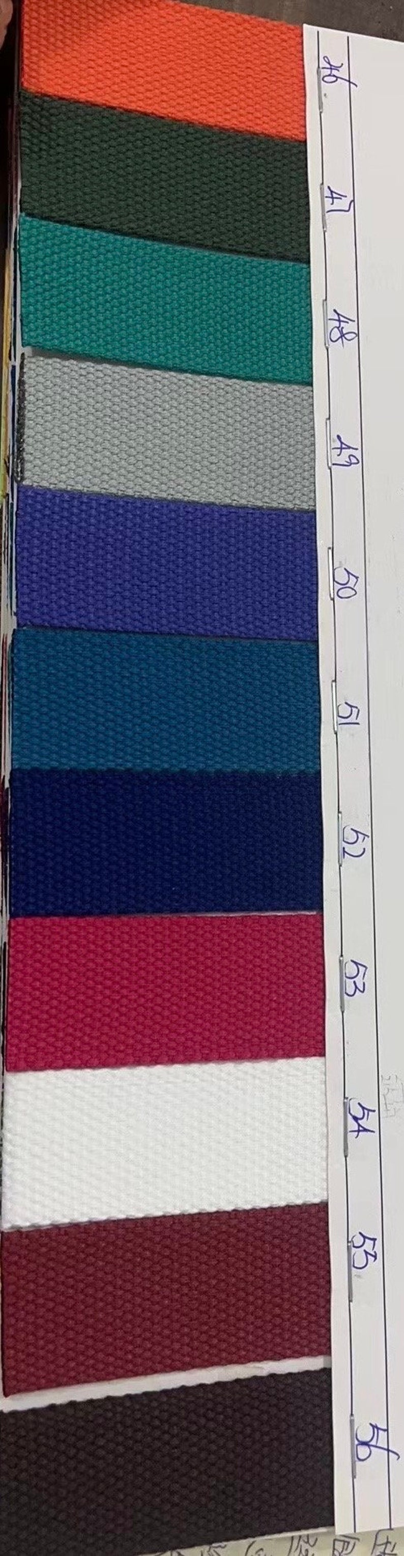 May include: A close-up of 10 fabric swatches with different colors and textures. The swatches are labeled with numbers 46 through 55.