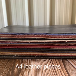 May include: A pile of A4 leather pieces in assorted colours, such as black, blue, and burgundy. The edges of the leather are visible, displaying the different layers and textures. The text "A4 leather pieces" is at the bottom.