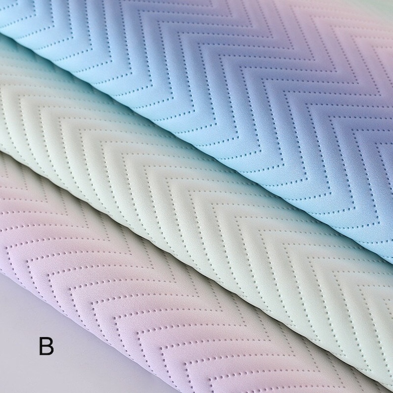 May include: Three pieces of fabric with a chevron pattern in shades of blue, green, and purple. The fabric has a textured surface and is quilted.