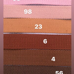 May include: Six different colored fabric straps with numbers printed on them. The numbers are 58, 98, 23, 6, 4, and 56.