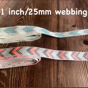 May include: Two rolls of 1 inch (25mm) wide chevron patterned webbing. One roll is light blue and grey, the other is light blue, grey, and coral.