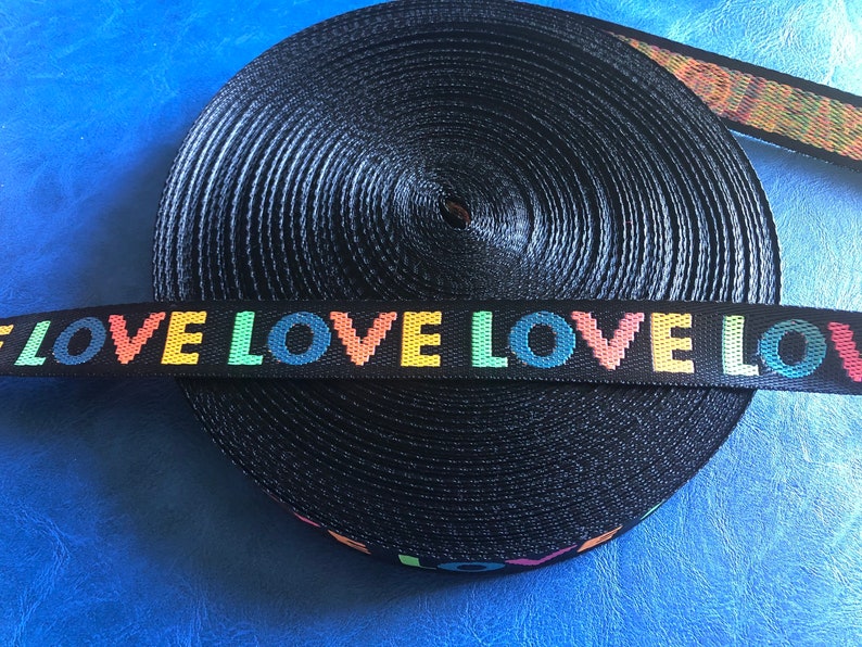 May include: Black webbing with the word "LOVE" repeated in rainbow colors.