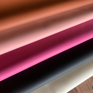 Puede incluir: Cinco muestras de tela de cuero sint&eacute;tico de diferentes colores. Los colores son marr&oacute;n, rosa, rosa claro, negro y gris claro.