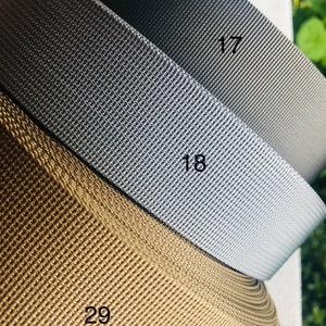 May include: Three rolls of webbing in different colors: brown, gray, and black. The rolls are labeled with the numbers 29, 18, and 17.