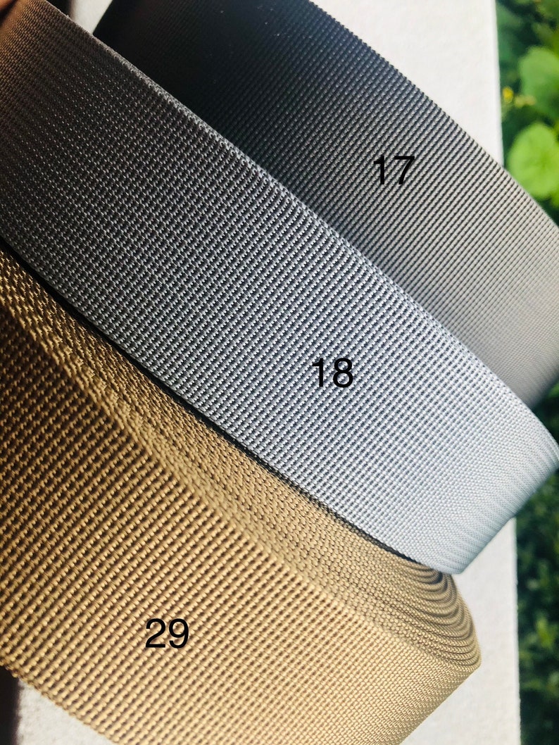 May include: Three rolls of webbing in different colors: brown, gray, and black. The rolls are labeled with the numbers 29, 18, and 17.