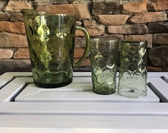 May include: A set of three green glass pitcher and glasses with a textured bubble design.