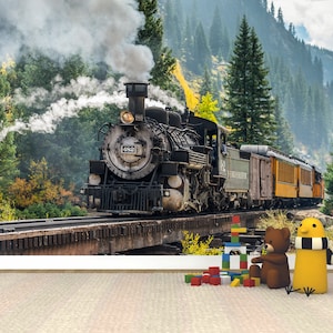 May include: A wall mural featuring a black steam locomotive numbered 482 travelling on a wooden trestle bridge through a forest with mountains in the background. In the foreground, a brown teddy bear, a yellow bird figure, and colourful building blocks.