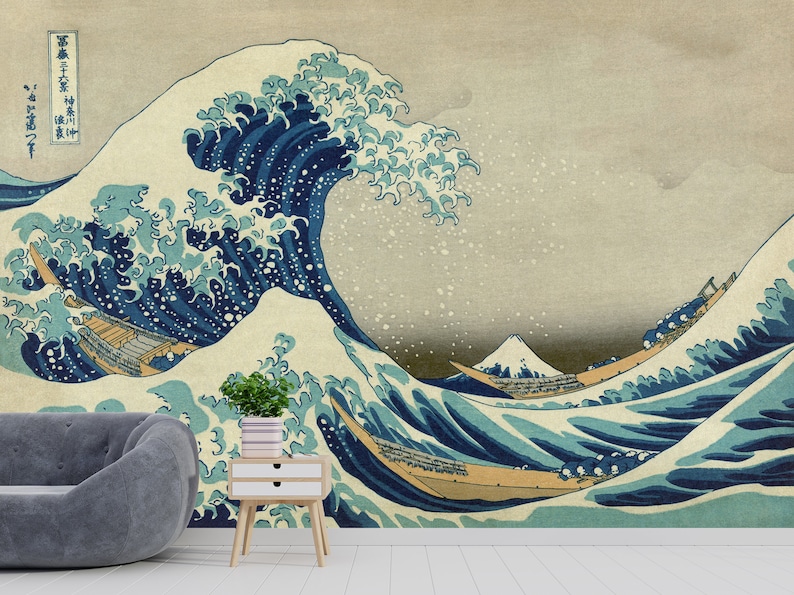 May include: A large blue wave with white foam crests, crashing over three traditional Japanese boats. The wave is depicted in a classic Japanese woodblock print style, with a background of light blue and white. The text in the upper left corner reads "神奈川沖浪裏" (Kanagawa oki nami ura), which translates to "Under the Wave off Kanagawa".