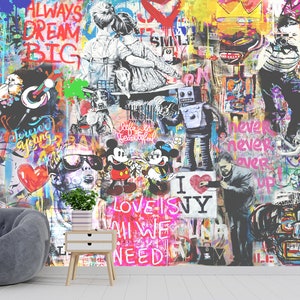 Op de afbeelding: Een muurschildering met een levendige collage van street art, inclusief graffititeksten zoals ALWAYS DREAM BIG, stripfiguren zoals Mickey en Minnie Mouse, een robot en diverse abstracte verfspatten in felle neon- en primaire kleuren.