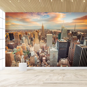 Puede incluir: Una vista panorámica del horizonte de la ciudad de Nueva York al atardecer, con el Empire State Building visible en la distancia.