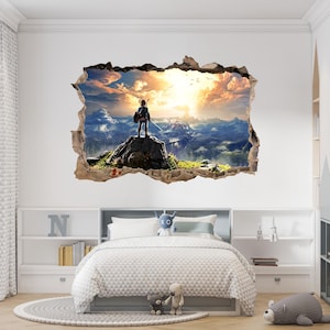 Puede incluir: Un vinilo decorativo con efecto 3D de un agujero en la pared que revela un paisaje. Una figura se encuentra sobre un afloramiento rocoso contemplando una vasta cadena monta&ntilde;osa bajo un cielo dorado al atardecer con nubes y aves volando.