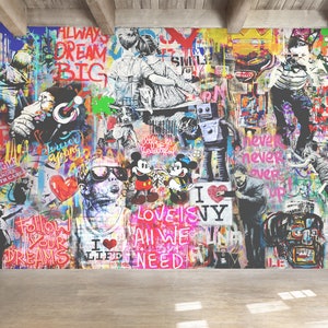 Op de afbeelding: Een grote muurschildering met een levendige collage van graffitikunst, waaronder Mickey en Minnie Mouse, een robot, kinderen en teksten zoals ALWAYS DREAM BIG, LOVE IS ALL WE NEED en I LOVE NY, tegen een veelkleurige, gelaagde achtergrond.