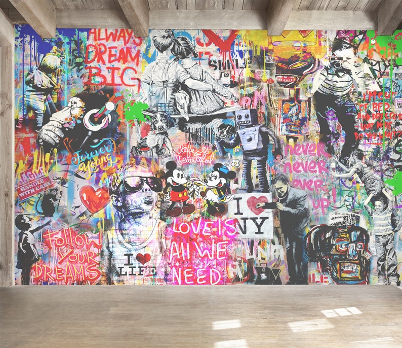 Op de afbeelding: Een grote muurschildering met een levendige collage van graffitikunst, waaronder Mickey en Minnie Mouse, een robot, kinderen en teksten zoals ALWAYS DREAM BIG, LOVE IS ALL WE NEED en I LOVE NY, tegen een veelkleurige, gelaagde achtergrond.