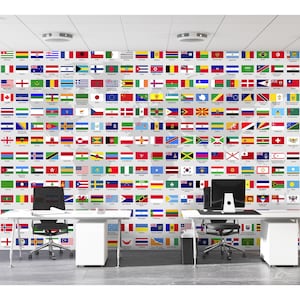 May include: An office interior with a wall decorated with flags of various countries. Two white desks with computers and chairs are positioned in front of the flag display. The flags are arranged in a grid.