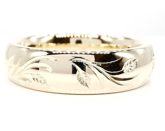 May include: A wide, silver-colored ring with a floral leaf design. The ring has a polished, reflective surface and is set against a white background. The ring's width is approximately 0.5 inches.