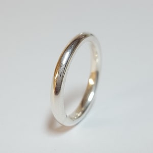 Puede incluir: Un anillo de banda simple de plata con un acabado liso y pulido.