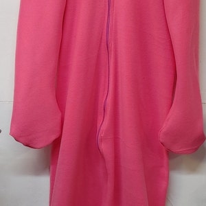 Op de afbeelding: Een roze hooded fleece jumpsuit met een ritssluiting en een hartvormige rits.