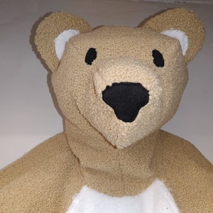 May include: A plush brown teddy bear with black eyes and a black nose. The bear has a white patch on its chest.