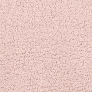 May include: Close-up of a light pink, textured fabric. The material has a dense, looped pile, creating a soft, plush appearance. The color is a muted pastel, suggesting a cozy or comforting textile.