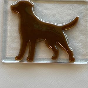 May include: A brown glass silhouette of a dog on a white background.
