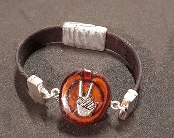 Einzigartiges  Armband aus dunkelbraunen Kork mit Peace Zeichen in einer Astscheibe eingegossen mit Epoxid.