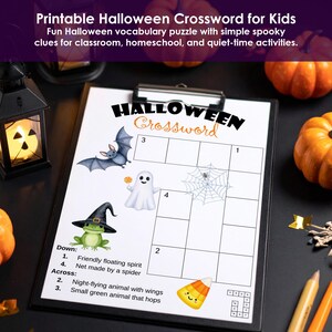 Printable Halloween crossword for kids on a clipboard with bat, ghost, frog and candy corn illustrations.