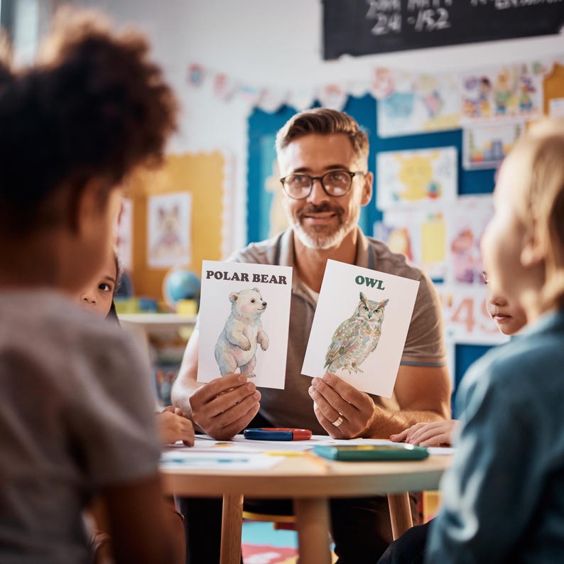 A teacher holds up two cards with animal illustrations in a classroom setting. One card shows a polar bear, the other an owl. The cards have the animal names printed above the images. Children are seated around a table.