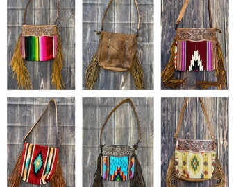 May include: Six different styles of brown leather purses with fringe. Each purse has a different colorful woven pattern on the front.