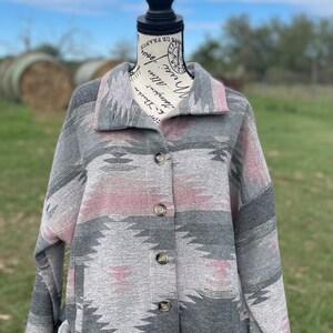 May include: A gray and pink patterned button-up jacket with long sleeves. The jacket has a southwestern-inspired design.