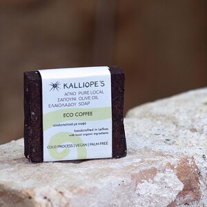 Może przedstawiać: Brązowe mydło z białą etykietą, na kt&oacute;rej widnieje napis "KALLIOPE'S AGNO PURE LOCAL SAPOUNI OLIVE OIL ELAIOLADOU SOAP ECO COFFEE &alpha;&pi;&omicron;&lambda;&epsilon;&pi;&iota;&sigma;&tau;&iota;&kappa;ό &mu;&epsilon; &kappa;&alpha;&phi;έ handcrafted in Lefkas with tocol orgonic ingredients COLD PROCESS | VEGAN | PALM FREE".