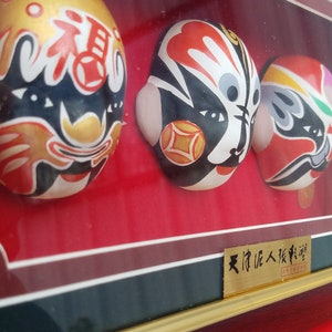 Chinese Opera Masks In Display Case. Zhong Guo Jing Ju Lian Pu