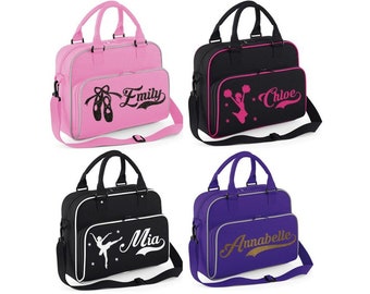 May include: Four personalized gym bags with different designs and names. The bags are pink, black, black, and purple. The designs include a pair of ballet shoes, a cheerleader, a ballerina, and a gold script.