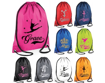 May include: Nine drawstring bags in various colors with different designs and names printed on them. The designs include a ballerina, a crown, a cheerleader, and a pair of ballet shoes. The names include Grace, Bethany, Abigail, Maya, Chloe, Scarlett, Freya, Emily, and Isabella.