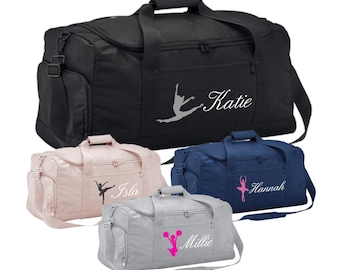 May include: Four black, pink, blue, and gray duffel bags with personalized names and a dancer silhouette. The names are Katie, Isla, Hannah, and Millie.