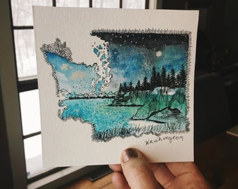 May include: Watercolor painting of the state of Washington with a night sky, moon, and stars. The painting is framed with a black outline and the word "Washington" is written in black at the bottom.