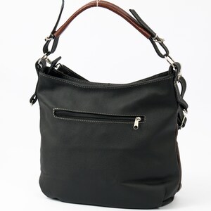 Pode incluir: Uma bolsa de m&atilde;o de couro preto com al&ccedil;a de couro marrom e ferragens prateadas. A bolsa tem um bolso com z&iacute;per na frente e um fecho de aba.