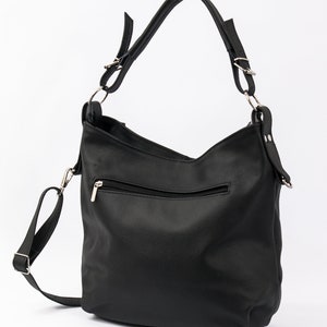 May include: Black leather shoulder bag with a zippered pocket and a long adjustable strap.