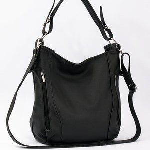 May include: A black leather shoulder bag with a long strap and silver hardware. The bag has a zippered pocket on the front.