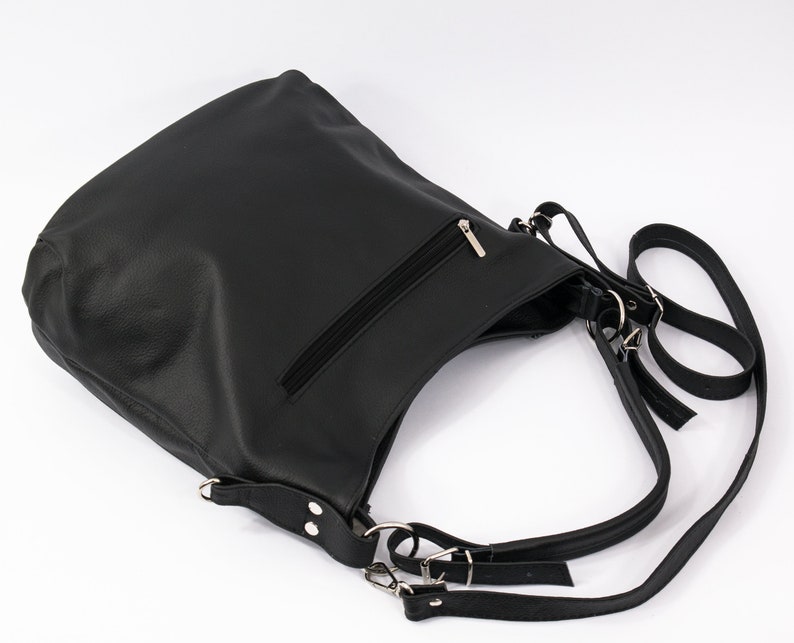 May include: Black leather shoulder bag with a zippered pocket and adjustable straps.
