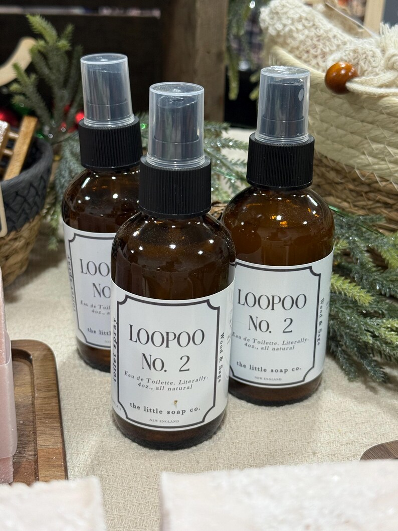 K&ouml;nnte beinhalten: Drei braune Glasspr&uuml;hflaschen mit schwarzen Kappen und wei&szlig;en Etiketten. Die Etiketten lauten "LOOPOO No. 2 Eau de Toilette. W&ouml;rtlich 118ml, ganz nat&uuml;rlich" und "the little soap co."