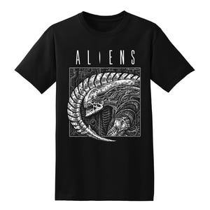 May include: Black t-shirt with the word "ALIENS" in white block letters above a detailed black and white illustration of an alien creature. The graphic features the alien's head and body.