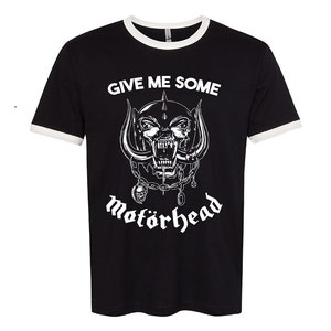 Könnte beinhalten: Schwarzes T-Shirt mit weißem Ringelkragen und einem weißen Motiv eines knurrenden Schädels mit Hörnern und Ketten. Der Text "Give Me Some" und "Motörhead" ist in Weiß gedruckt.